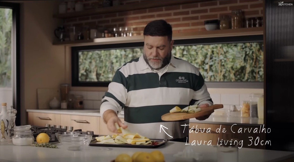 Tábua de Carvalho Laura Living - Pizza M - 30 CM Homem a preparar alimentos numa cozinha moderna com tábua de carvalho