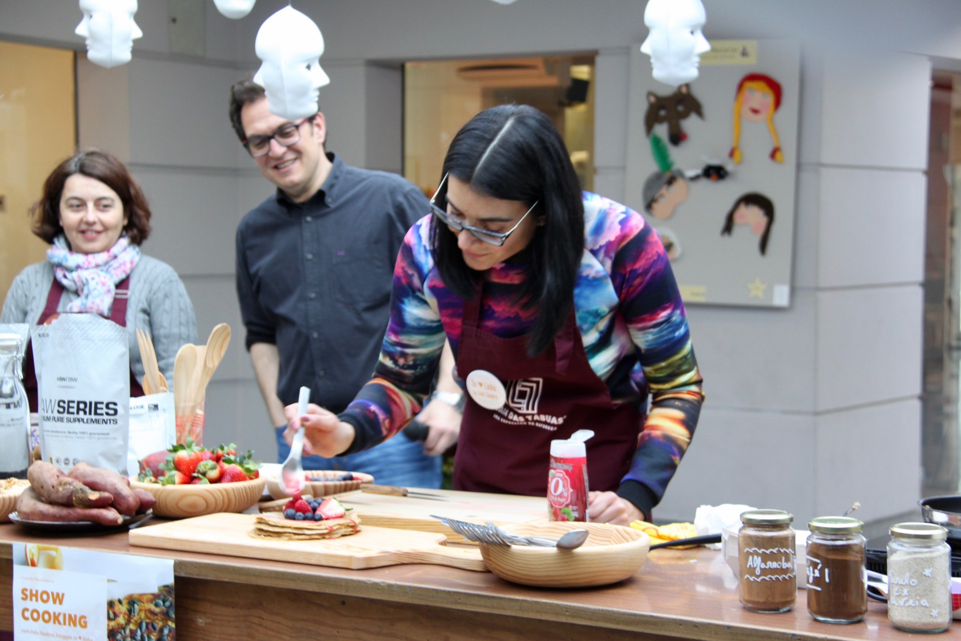 Mulher a preparar panquecas com ingredientes num balcão de madeira em ambiente interior
