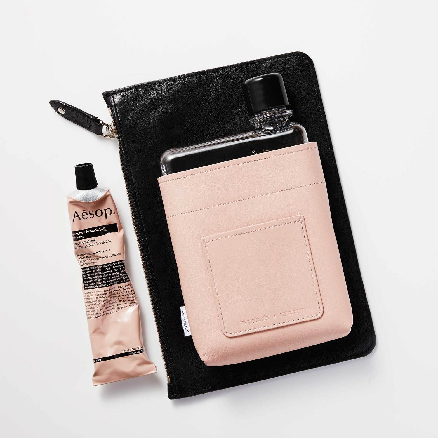 A6 Nude Leather Sleeve memobottle Bolsa preta, garrafa em suporte rosa e creme Aesop