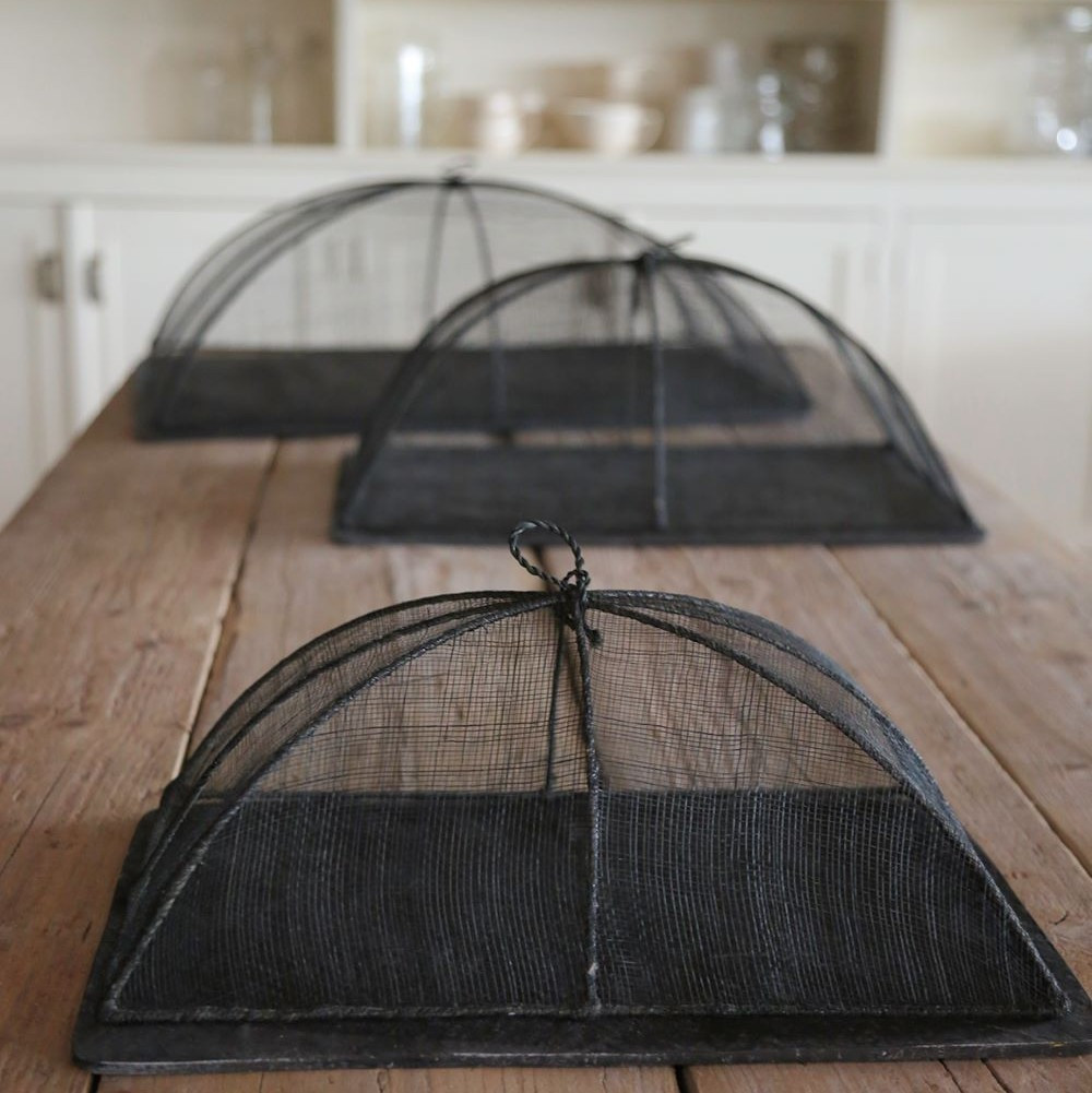 Cobertura alimentar em rede abaca 25x40x14cm - preto Tampas de rede pretas em forma de cúpula sobre uma mesa de madeira