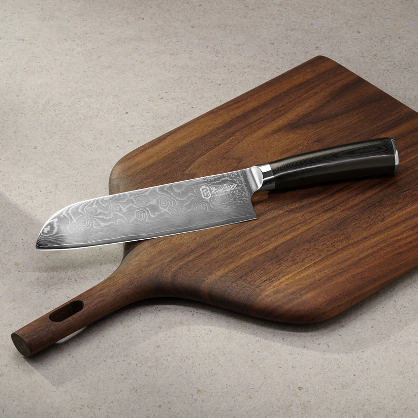 Faca Santoku Bacher em Aço Damasco com Pano de Limpeza e Cera Protetora Faca de chef em aço damasco com cabo preto sobre tábua de madeira escura