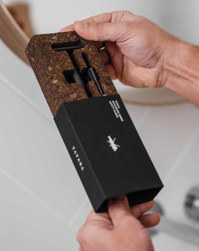MASAMUNE RAZOR - BLACK Lâmina de barbear preta em embalagem preta e castanha com texto e logótipo, mãos seguram o produto