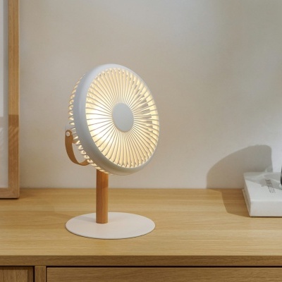 Ventoinha branca e castanha sobre superfície de madeira ao lado de jarro de vidro e livro