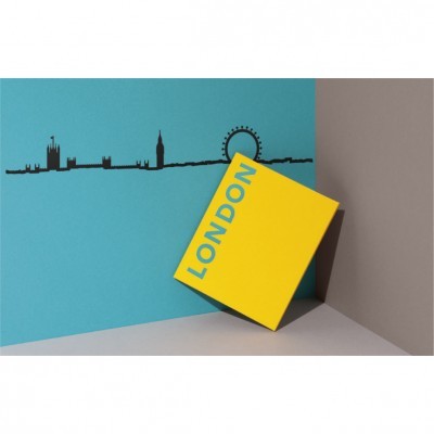 Caixa amarela LONDON junto a parede azul com desenho da linha do horizonte de Londres