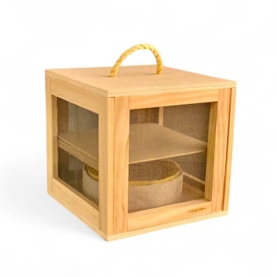 Caixa quadrada de madeira com painéis de tela e alça de corda amarela.