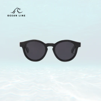 Óculos de sol com armação preta imitando madeira e lentes escuras com fundo azul claro e logotipo Ocean Line