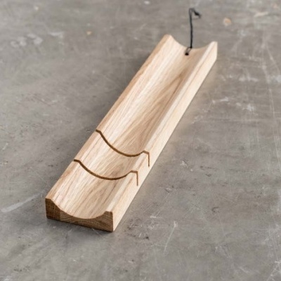 Base de madeira clara com ranhuras curvas e cordão preto