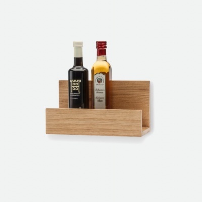 Prateleira de madeira clara com duas garrafas, uma preta com tampa branca e uma amarela com tampa vermelha