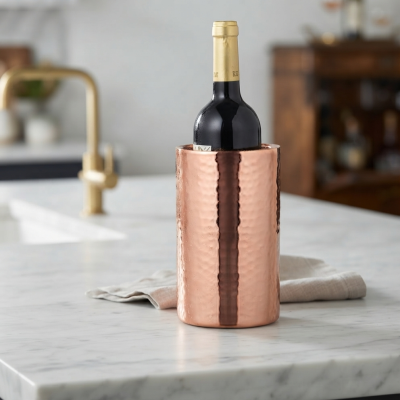 garrafa de vinho num balde de vinho cobre martelado numa bancada de mármore