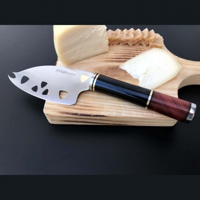 Faca para queijo com lâmina de aço inoxidável e cabo em madeira numa tábua de madeira clara com queijo