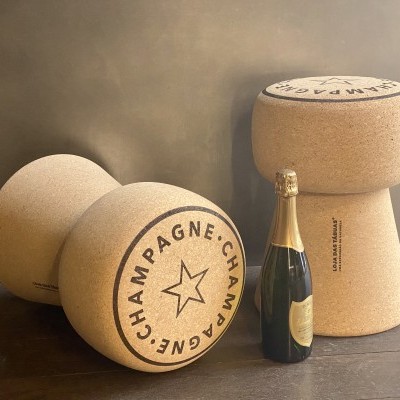 Bancos de cortiça em forma de rolha de champanhe com garrafa de champanhe ao centro