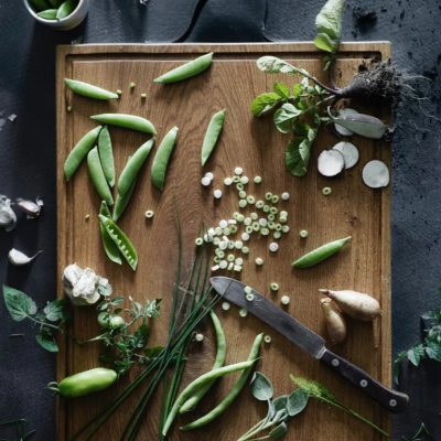 Tabuleiro de madeira com legumes frescos e ervas verdes