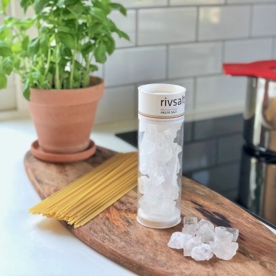 Frasco de sal grosso em frasco transparente com esparguete e planta verde na cozinha
