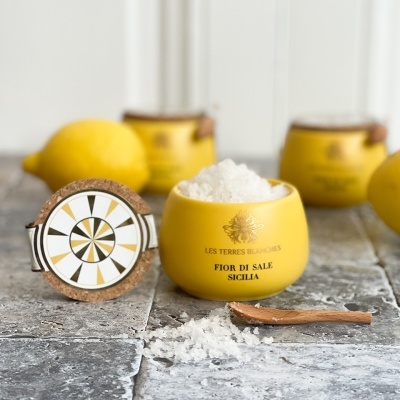 Pote amarelo cerâmico com sal grosso branco, tampa de cortiça e colher de madeira