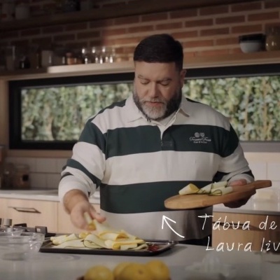 Homem a preparar alimentos numa cozinha moderna com tábua de carvalho