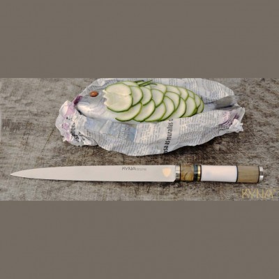 Peixe decorado com pepino em jornal ao lado de faca KYNA