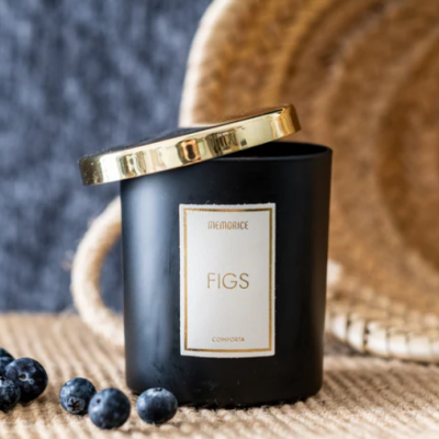 Vela MEMORICE FIGS em copo preto com tampa dourada sobre superfície de corda com mirtilos ao lado