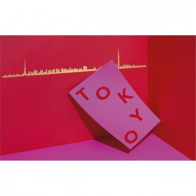 Cartão cor-de-rosa com letras 'TOKYO' vermelho inclinado com fundo vermelho e rosa e skyline dourado de Tóquio ao fundo