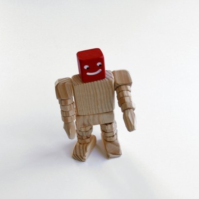 Boneco articulado de madeira com cabeça vermelha e sorriso