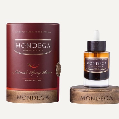 Frasco de molho e embalagem MONDEGA sobre bases de madeira