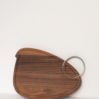 Tabua de corte de madeira escura com aro metálico circular