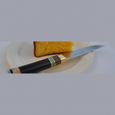 Faca com cabo em madeira e detalhes metálicos sobre prato branco com fatia de bolo