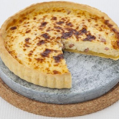 Tarte folhada gratinada numa base de pedra cinzenta e cortiça