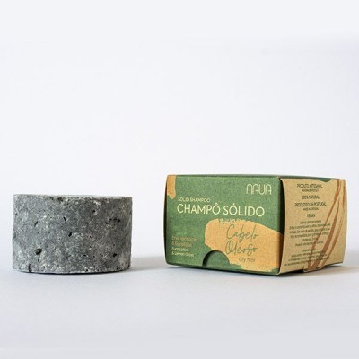 Champô sólido cinza poroso e embalagem verde e castanha com texto em português