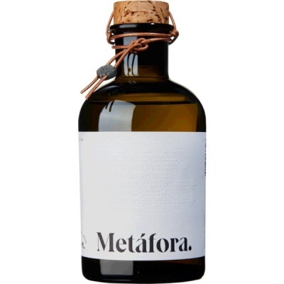 Garrafa de vidro âmbar com rolha de cortiça e etiqueta branca com texto Metáfora.