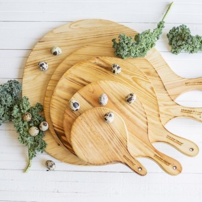 Tábuas de cozinha de madeira clara com ovos de codorniz e raminhos verdes