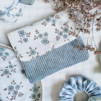 Carteira, mala e elásticos de cabelo com padrões florais e xadrez em tons azuis, bege e verde claro