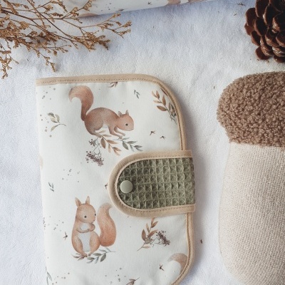 Capa ou bolsa estampada com esquilos, fecho verde e objeto têxtil castanho e bege