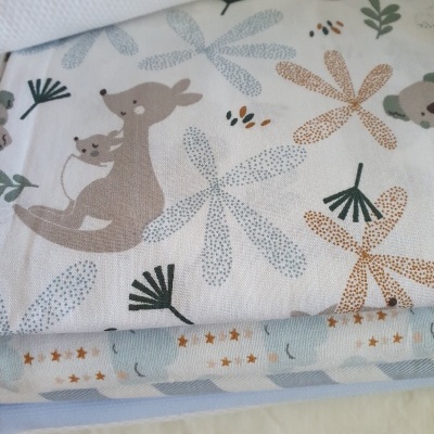 Mantinhas empilhadas com padrões de cangurus, folhas e estrelas