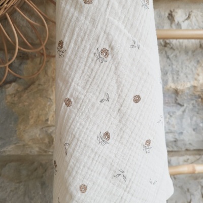 Pano branco texturado com padrão floral pendurado em estrutura de madeira