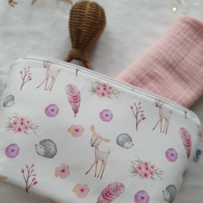 Bolsa de tecido branca com padrões de veados, ouriços, flores e penas em tons pastel.