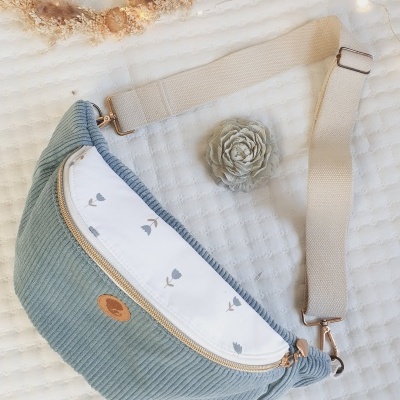 Bolsa veludo cotelê azul com pala branca e padrão floral, alça bege ajustável