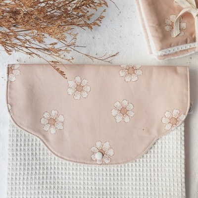 Toalha branca textura waffle com aba rosa flores brancas e castanhas e botão de pressão