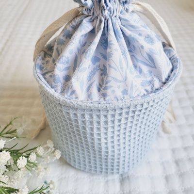 Saco de tecido azul claro com padrão floral e parte inferior em malha quadriculada