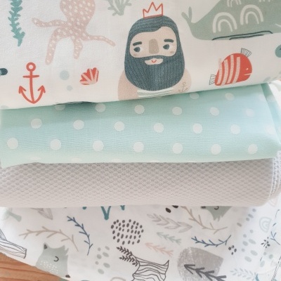 Conjunto de quatro tecidos com vários padrões incluindo marinho, bolinhas, malha e padrão vegetal.