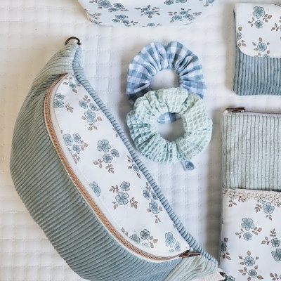 Conjunto de acessórios azul com padrão floral e tecidos variados.