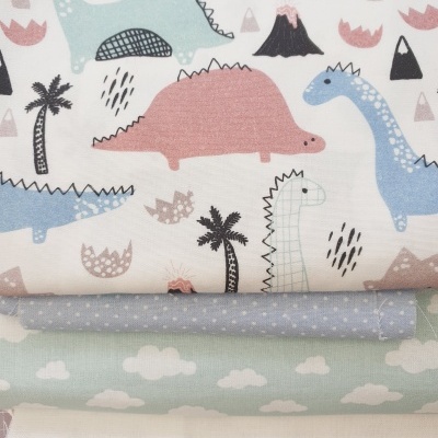 Tecidos empilhados com padrões de dinossauros, pontos e estrelas