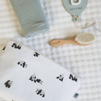 bolsa branca com pandas pretos, escova de madeira, toalha verde, enfeite cinza com letra B e nome Beatriz