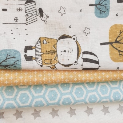 Conjunto de tecidos infantis com padrões de urso, árvores, estrelas e formas geométricas em cores azul, laranja, branco e cinza.