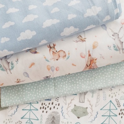 Conjunto de quatro tecidos com padrões de nuvens, animais, pontos e floresta em cores suaves.