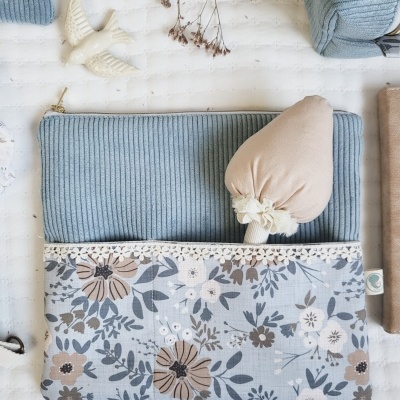 Estojo de tecido azul e floral com objeto de tecido bege