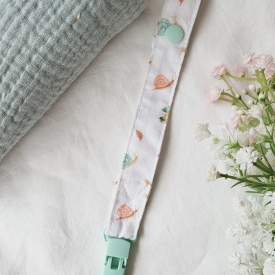 Clipe para chupeta branco com caracóis coloridos e fecho verde