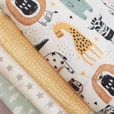 Quatro tecidos infantis com padrões coloridos, incluindo animais, pintas, estrelas e nuvens.