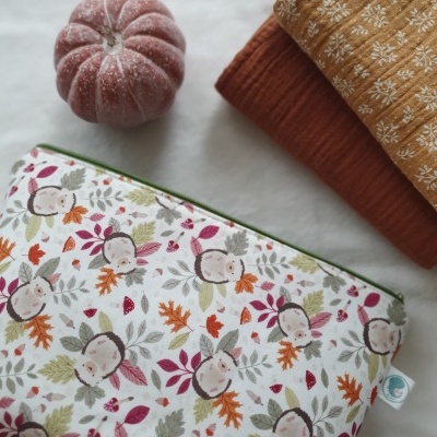 Bolsa estampada com raposas e folhas, tecidos dobrados em tons terra e abóbora decorativa cor de rosa