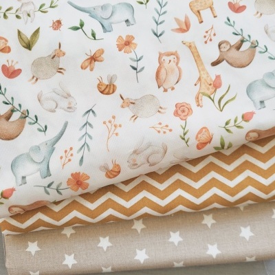 Quatro tecidos com padrões animais, zig-zag, estrelas e liso em cores suaves.