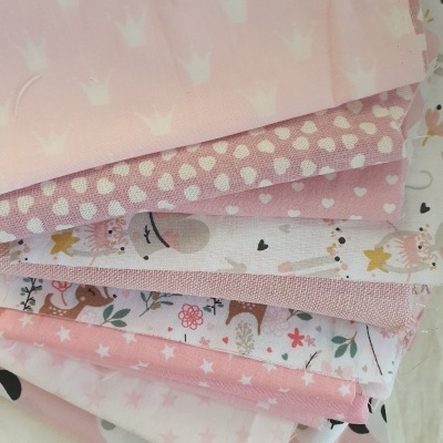Tecidos de algodão em rosa e branco com vários padrões infantis e geométricos